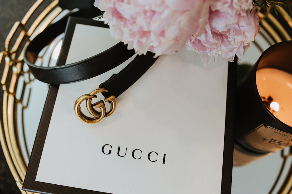 Luxurious close-up of a Gucci belt with a candle and flowers, showcasing elegance and style.