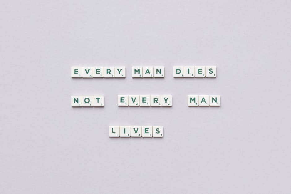 Scrabble tiles spelling 'Every man dies, not every man lives' on gray background.
