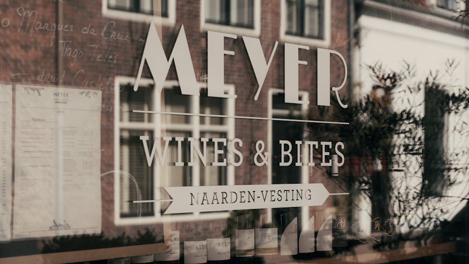 Elegant reflection of wine shop window with bottles and logo in Naarden, Netherlands.